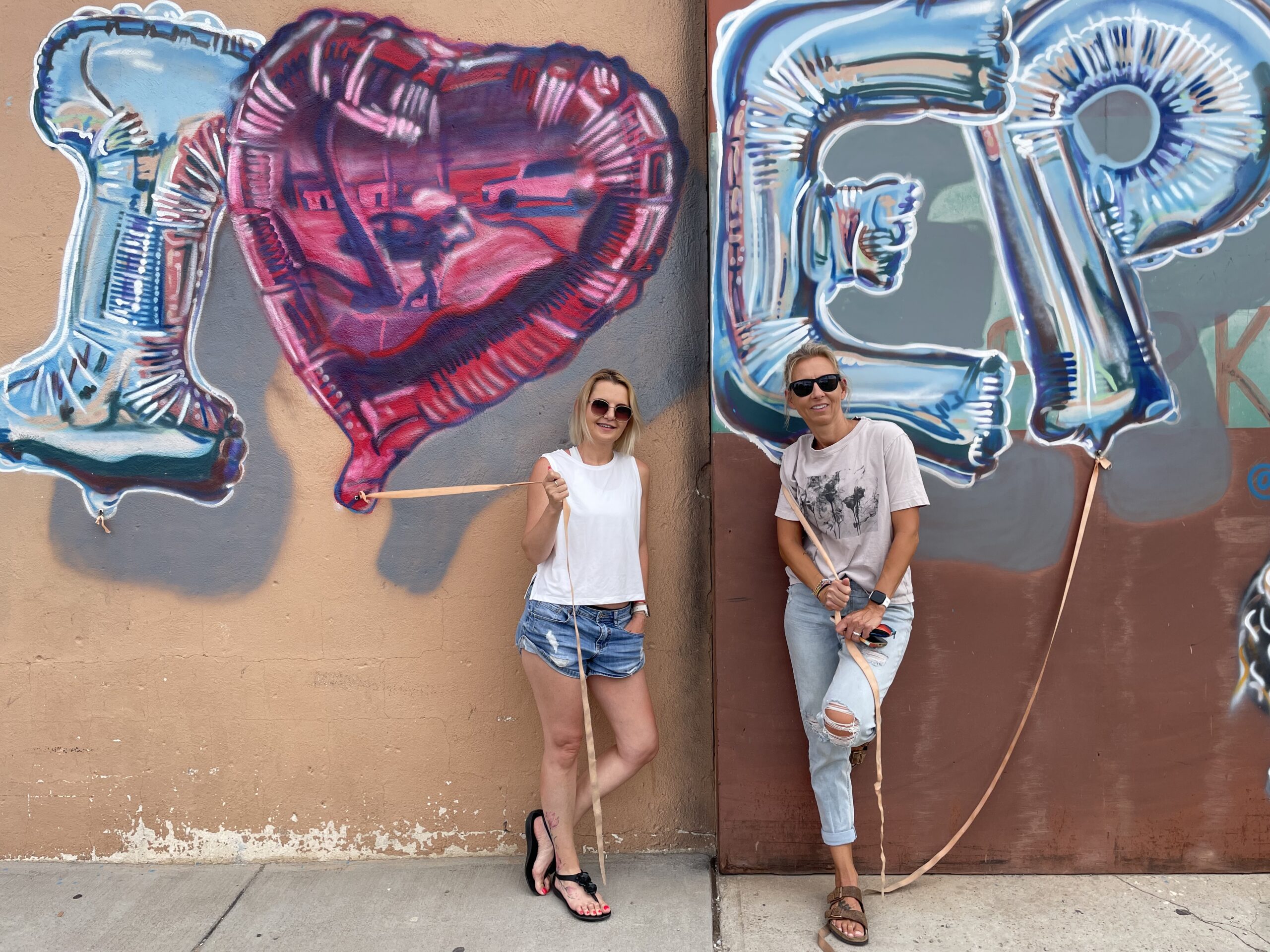 Two longtime friends by an I Love El Paso mural