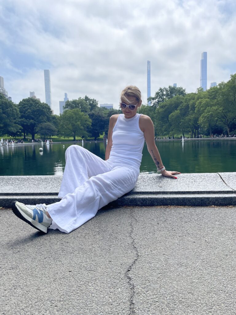 Woman wearing white New Balance 327 sneakers while walking in Central Park, New York City.