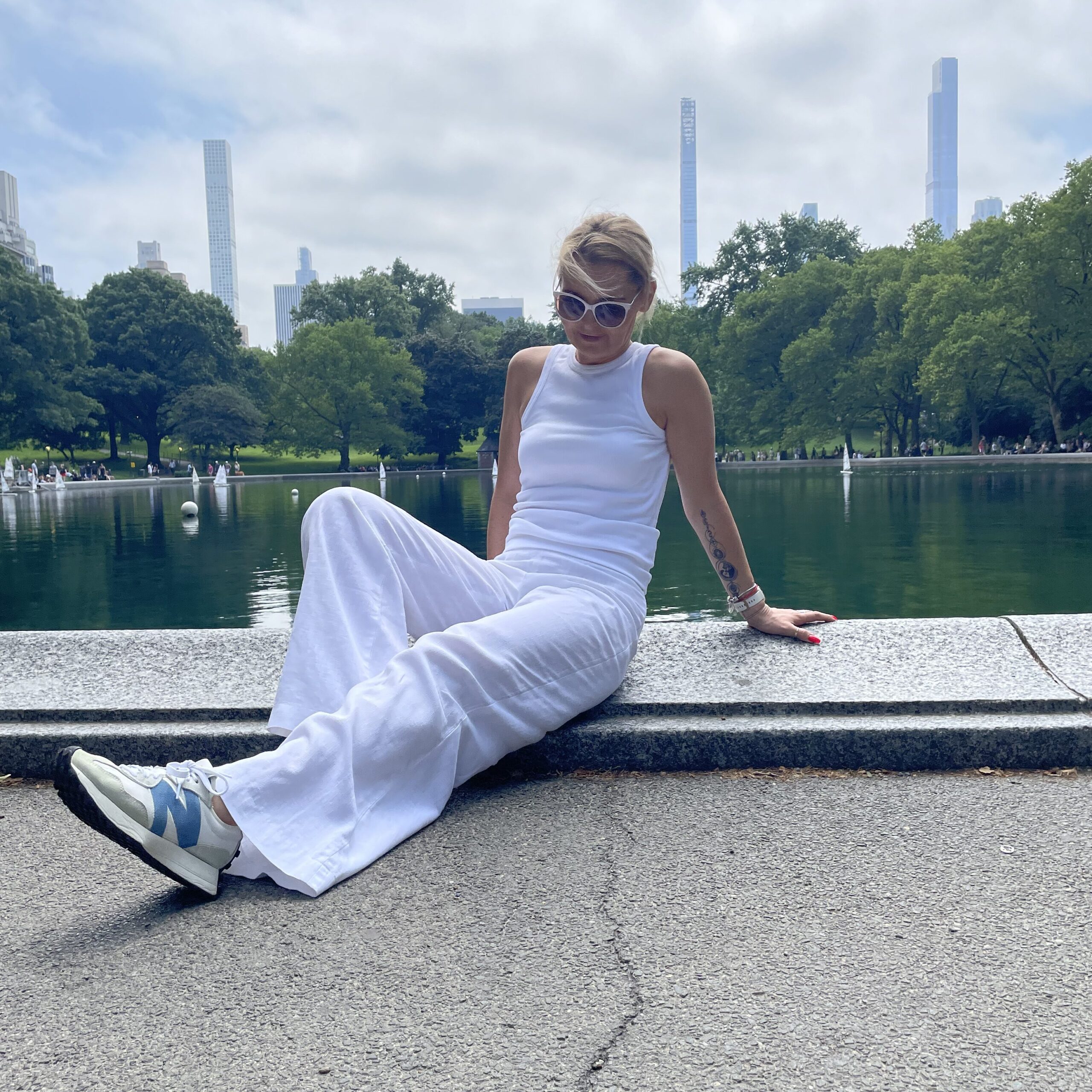 Woman wearing white New Balance 327 sneakers in Central Park, New York City.
