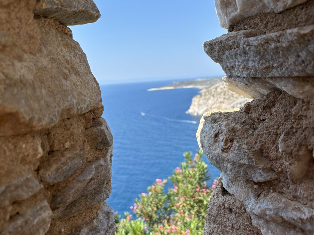 View of the Aegean Sea through rocky cliffs on Thassos, Greece.