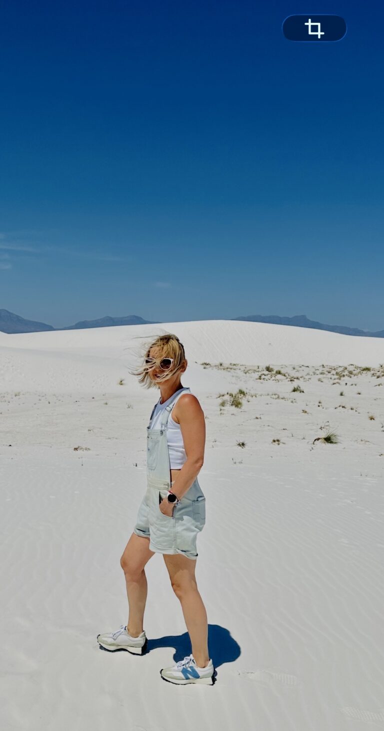 A person walking across the bright white gypsum dunes at White Sands National Park in New Mexico.