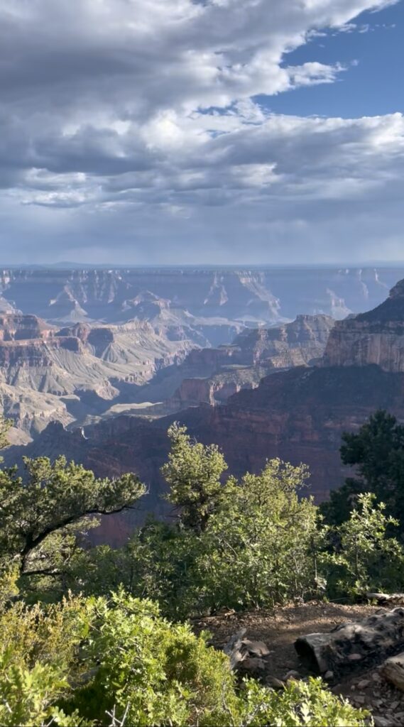 Wide view of the Grand Canyon from the North Rim in Arizona under dramatic summer clouds.